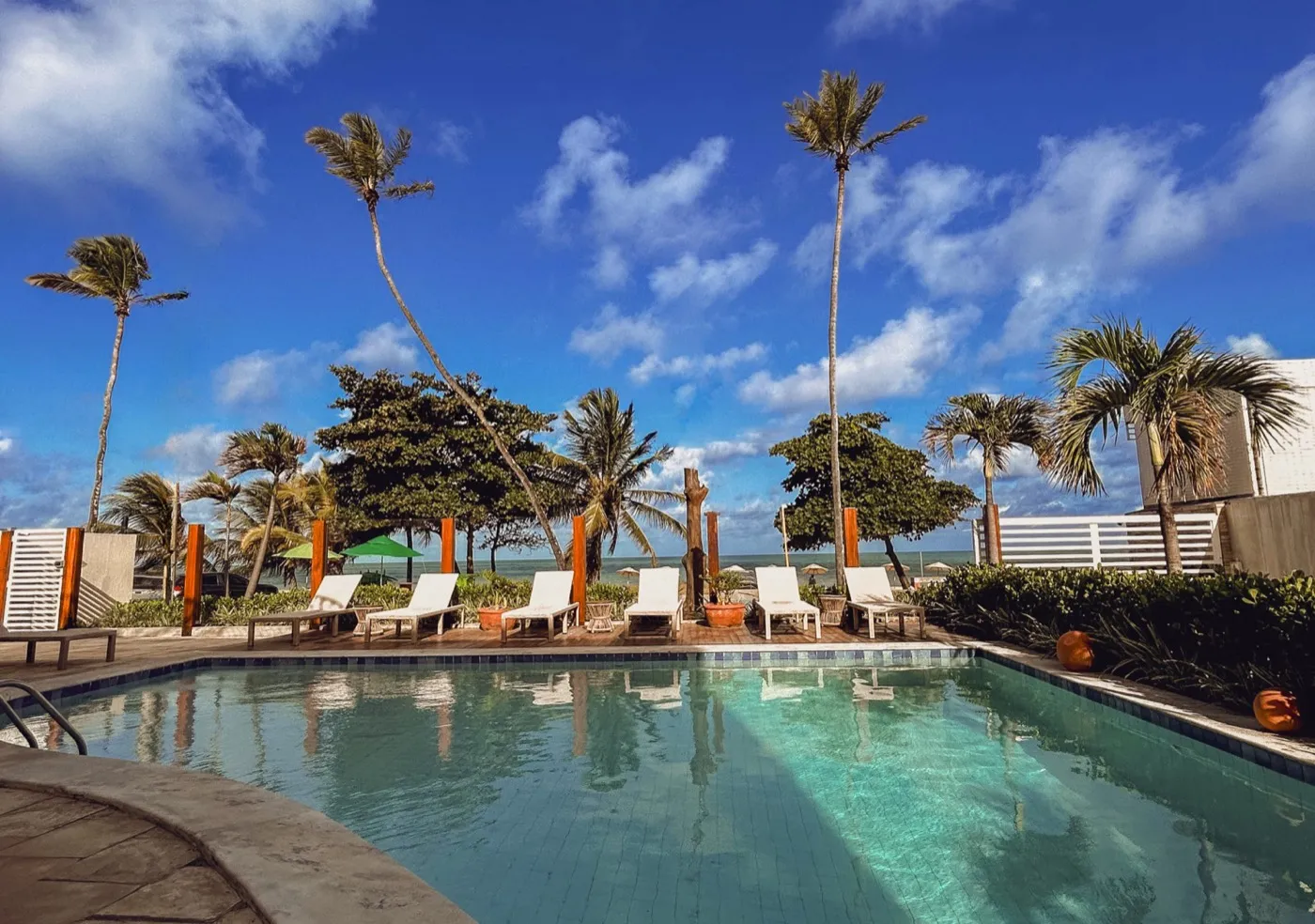 Piscina do Kastel Jampa de frente para o mar, com coqueiros e espreguiçadeiras